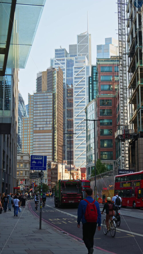 London, England – May 13, 2025: Modern glass skyscrapers of London’s financial district reflecting the blue sky next to historic architecture. Vertical - Starpik Stock