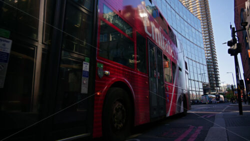 London, England – May 13, 2025: Red double-decker bus near Primrose street with reflective glass buildings around - Starpik Stock