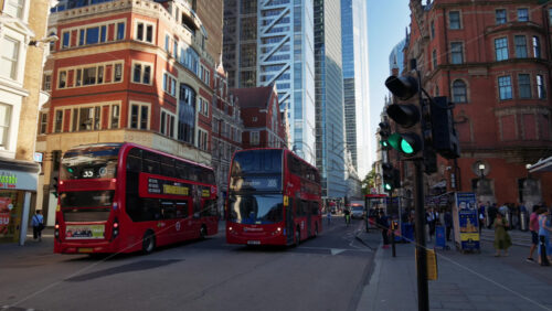 London, England – May 13, 2025: Red double-decker buses passing through the financial district of the city near Liverpool Station - Starpik Stock