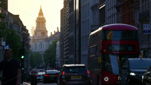 London, England – May 13, 2025: Sunset city view featuring traffic and a red double-decker bus with St. Paul’s Cathedral in the background - Starpik Stock