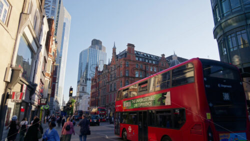 London, England – May 13, 2025: View of Bishopsgate in London with crowds crossing, taxis and buses moving past historic and modern architecture including Liverpool Street Station’s glass entrance - Starpik Stock