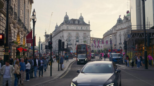 London, England – May 14, 2025: Crowded street near Piccadilly Circus with flags and traffic - Starpik Stock