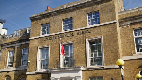 London, England – May 14, 2025: Exterior view of the historic London Nautical School with brick facade and British flag - Starpik Stock