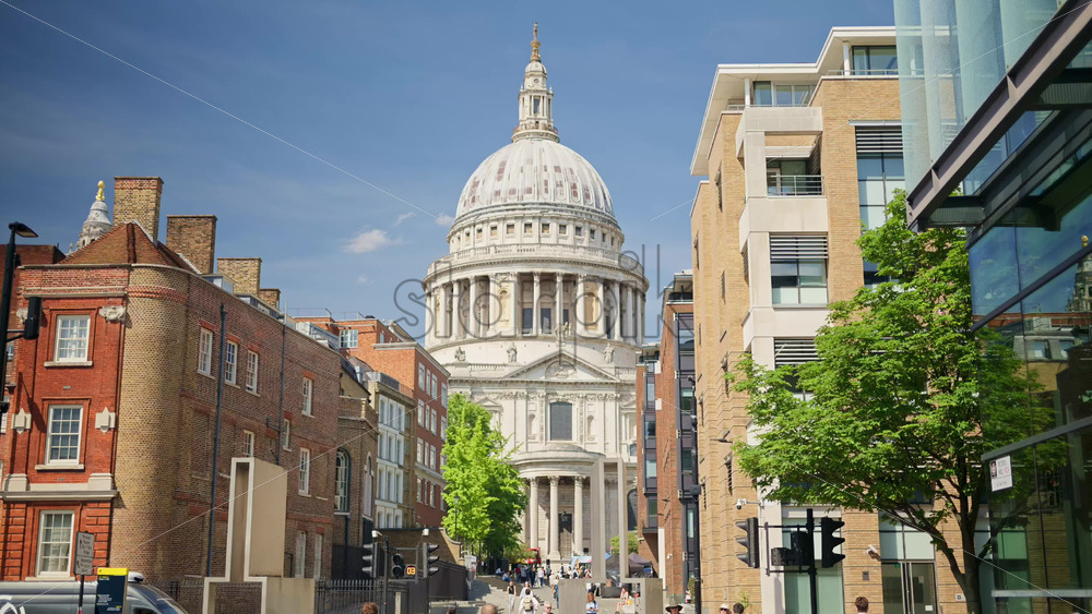 London, England – May 14, 2025: Framed view of St. Paul’s Cathedral dome between two modern brick buildings - Starpik Stock