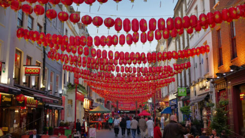 London, England – May 14, 2025: People moving through China Town under red paper lanterns in the evening - Starpik Stock