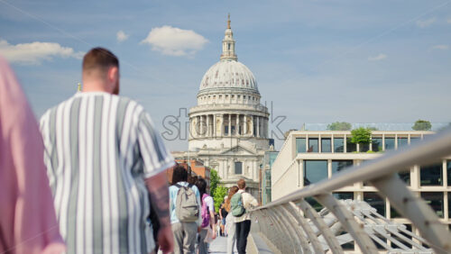 London, England – May 14, 2025: People walking on Millennium Bridge with St. Paul’s Cathedral in the background - Starpik Stock