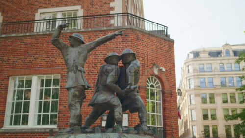 London, England – May 14, 2025: Statue of World War I soldiers with red-brick building background and a Sermon Lane sign in daylight - Starpik Stock