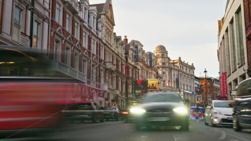 London, England – May 14, 2025: Time lapse of a lively street with cars and double-decker buses and colourful lights in the evening - Starpik Stock