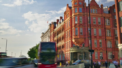 London, England – May 14, 2025: Time lapse of traffic moving past Royal Waterloo Hospital for Children and Women grand historic red-brick building in the city - Starpik Stock