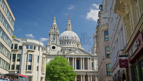 London, England – May 14, 2025: View of St. Paul’s Cathedral with red buses and cars along a busy street - Starpik Stock
