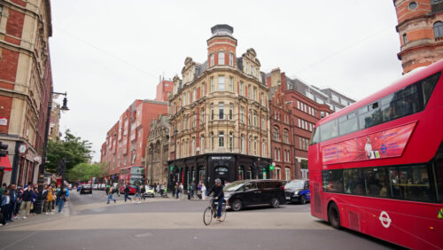 London, England – May 15, 2025: A busy street with classic brick buildings, cars, buses, and pedestrians - Starpik Stock