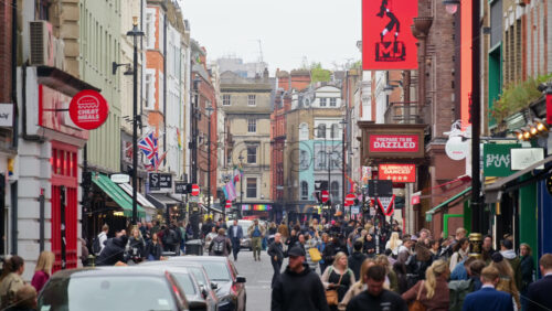 London, England – May 15, 2025: A crowded street bustling with pedestrians, shops, and colourful storefront signs in London’s Soho district - Starpik Stock