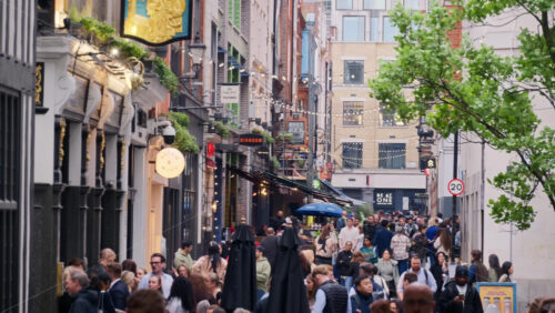 London, England – May 15, 2025: Busy pedestrian street scene near Carnaby Street with many people walking and socializing under string lights. - Starpik Stock