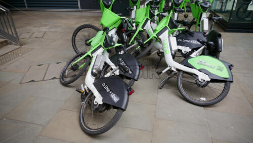London, England – May 15, 2025: Close-up of Lime and Uber rental bikes crashed on a street - Starpik Stock