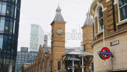 London, England – May 15, 2025: Iconic twin clock towers of Liverpool Street Station with a nearby London Underground sign marking - Starpik Stock