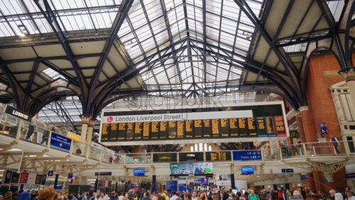 London, England – May 15, 2025: Interior of the busy Liverpool Street train station with a high glass ceiling and brick walls filled with commuters - Starpik Stock
