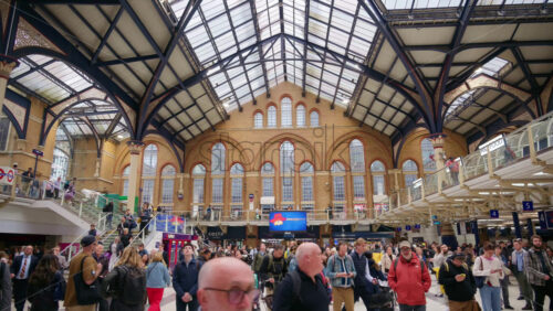 London, England – May 15, 2025: Interior of the busy Liverpool Street train station with a high glass ceiling and brick walls filled with commuters - Starpik Stock