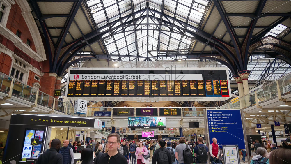 London, England – May 15, 2025: Interior of the busy Liverpool Street train station with a high glass ceiling and brick walls filled with commuters - Starpik Stock