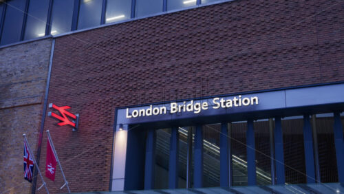 London, England – May 15, 2025: London Bridge Station entrance, showing the brick facade and station sign, with the British Rail logo and flags - Starpik Stock