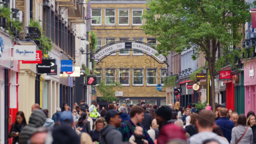 London, England – May 15, 2025: People walking under Carnaby Street sign with many store signs - Starpik Stock