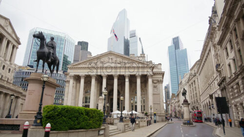 London, England – May 15, 2025: Royal Exchange building with surrounding skyscrapers and monument statues - Starpik Stock