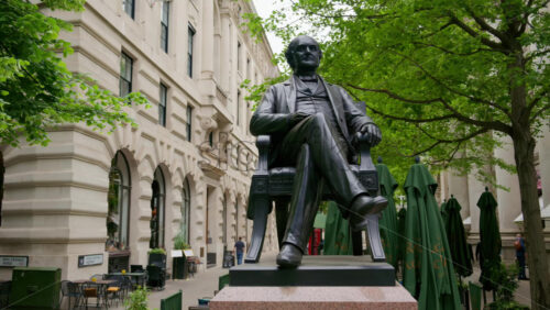 London, England – May 15, 2025: Statue of George Peabody with classic architecture and green trees in the background - Starpik Stock