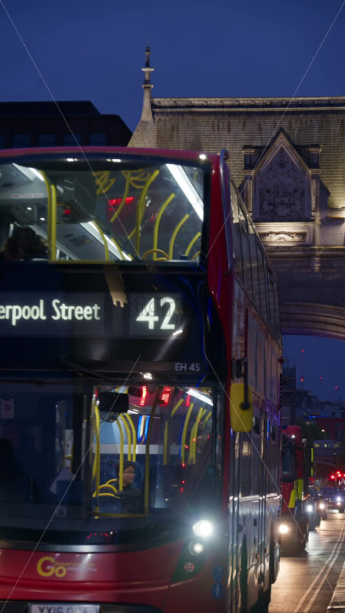 London, England – May 15, 2025: Tower Bridge close-up with cars moving on the bridge and its iconic towers lit up in blue. Vertical - Starpik Stock