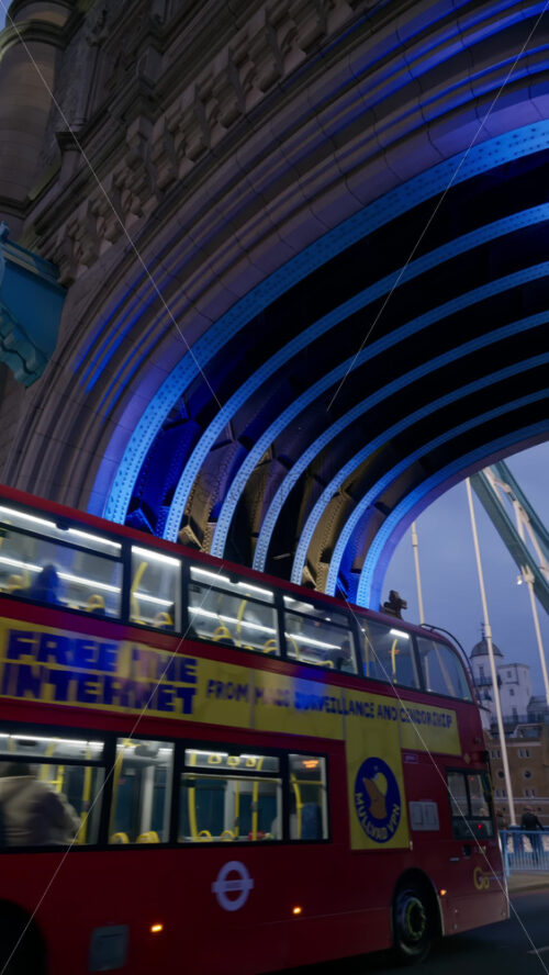 London, England – May 15, 2025: Tower Bridge close-up with cars moving on the bridge and its iconic towers lit up in blue. Vertical - Starpik Stock