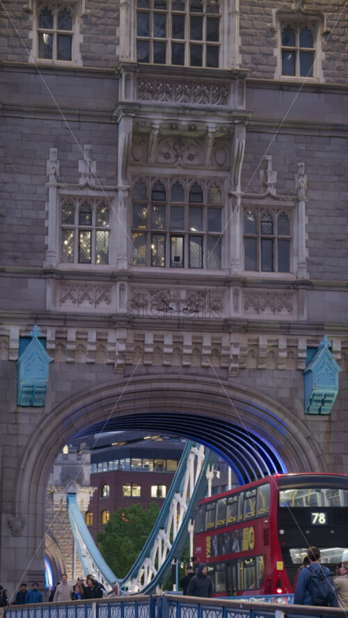 London, England – May 15, 2025: Tower Bridge close-up with cars moving on the bridge and its iconic towers lit up in blue. Vertical - Starpik Stock