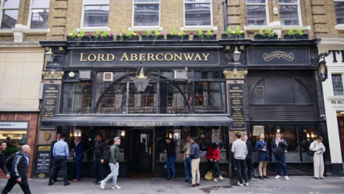 London, England – May 15, 2025: Traditional British pub Lord Aberconway on Old Broad Street surrounded by bustling office workers enjoying after-hours drinks near Liverpool Station - Starpik Stock
