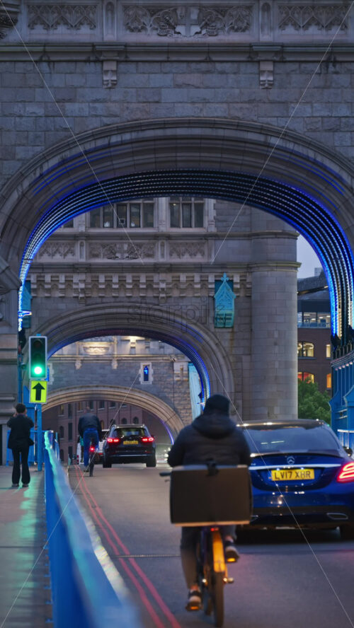 London, England – May 15, 2025:Tower Bridge close-up with cars moving on the bridge and its iconic towers lit up in blue. Vertical - Starpik Stock