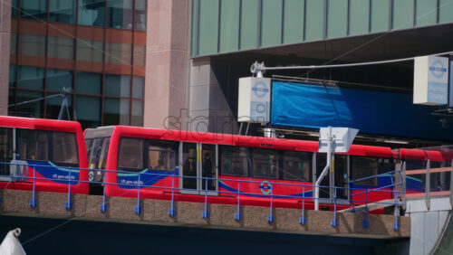 London, England – May 16, 2025: A Docklands Light Railway train arriving at Heron Quays station in Canary Wharf - Starpik Stock