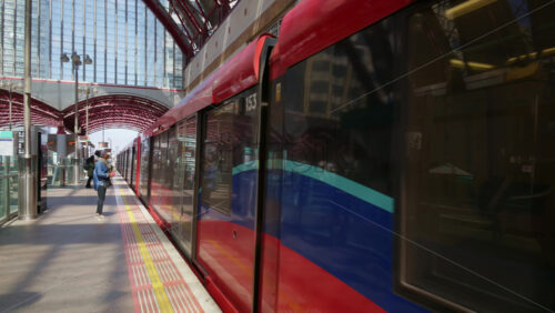 London, England – May 16, 2025: A busy platform at Canary Wharf DLR station with a train arriving - Starpik Stock