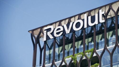 London, England – May 16, 2025: Close-up of the Revolut logo on a sleek office building facade in Canary Wharf - Starpik Stock