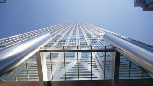 London, England – May 16, 2025: Low-angle view of a contemporary One Canada Square skyscraper reflective glass facade supported by shiny steel columns in Canary Wharf - Starpik Stock