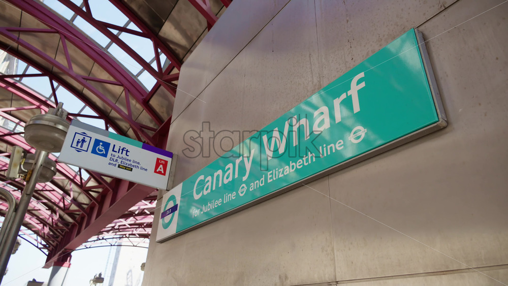 London, England – May 16, 2025: View of the Canary Wharf London Underground station sign indicating access to the Jubilee Line, DLR, and Elizabeth Line - Starpik Stock