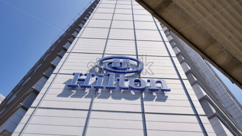 London, England – May 16, 2025: View of the Hilton hotel logo on a tall modern building in Canary Wharf - Starpik Stock