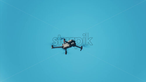Low angle view of a drone hovering against a vivid blue sky - Starpik Stock