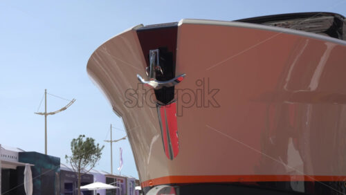 Low angle view of a glossy yacht bow showcasing polished chrome anchor hardware against a clear blue sky - Starpik Stock