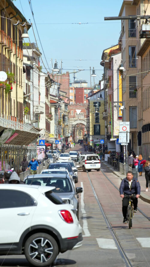 Milan, Italy – March 20, 2025: People and cars moving on the streets of the city in daylight. Vertical - Starpik Stock