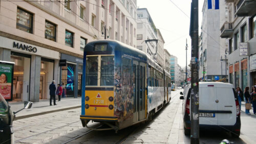 Milan, Italy – March 20, 2025: People, cars and public transportation moving on the streets of the city in daylight - Starpik Stock