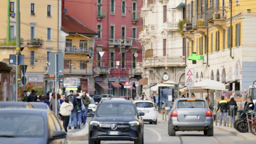 Milan, Italy – March 20, 2025: People, cars and public transportation moving on the streets of the city in daylight - Starpik Stock