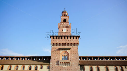Milan, Italy – March 20, 2025: People walking at the Sforzesco Castle, near the Filarete Tower in daylight - Starpik Stock