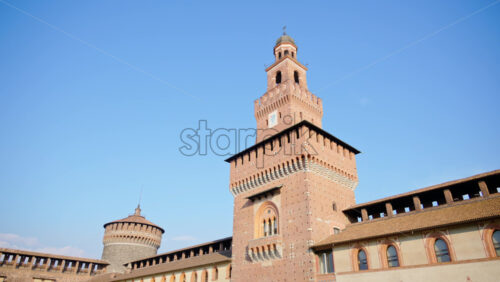 Milan, Italy – March 20, 2025: People walking at the Sforzesco Castle, near the Filarete Tower in daylight - Starpik Stock
