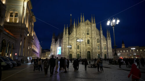 Milan, Italy – March 21, 2025: Multiple people walking through the Duomo Square in the evening - Starpik Stock