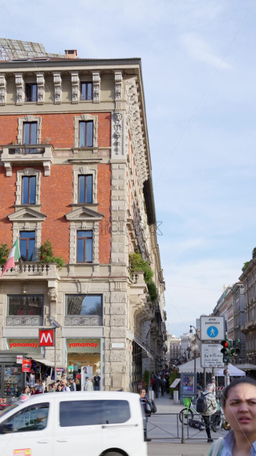 Milan, Italy – March 21, 2025: People and cars moving on the streets of the city in daylight. Vertical - Starpik Stock