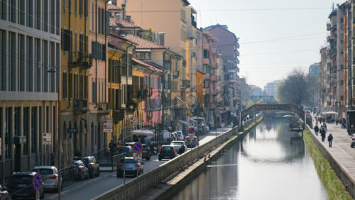Milan, Italy – March 21, 2025: People and cars moving on the streets surrounding the Naviglio Canal in daylight - Starpik Stock