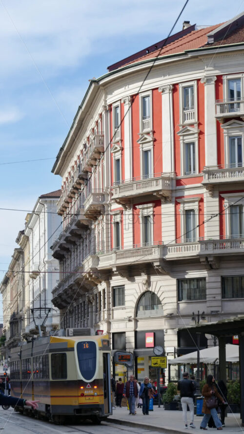 Milan, Italy – March 21, 2025: People and public transportation moving on the streets of the city in daylight. Vertical - Starpik Stock