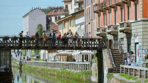 Milan, Italy – March 21, 2025: People standing on the bridge above the Naviglio Grande Canal in daylight - Starpik Stock