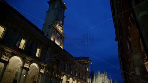 Milan, Italy – March 21, 2025: People walking by the Palazzo dei Giureconsulti in the evening with the Duomo on the background - Starpik Stock